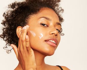 mixed girl applying creme to face