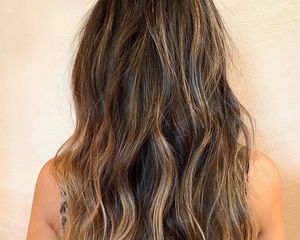 Back view of woman with cool brown hair and warm honey highlights