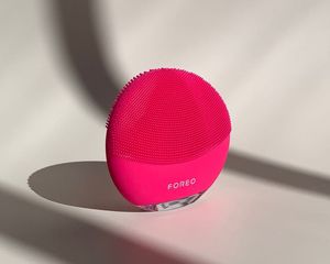 A hot pink Foreo Luna on a white, shadowy background