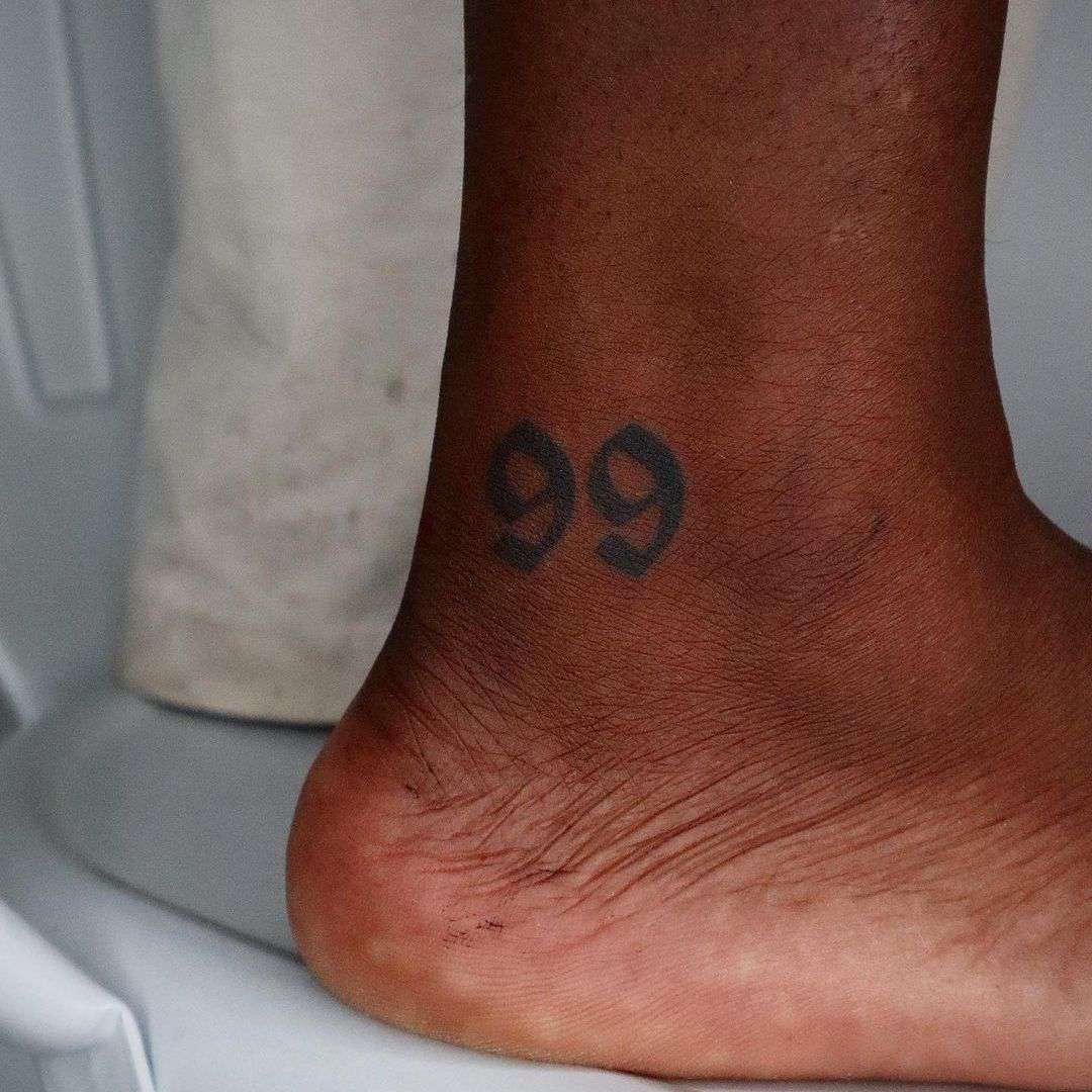 Ankle tattoo with opaque number 99