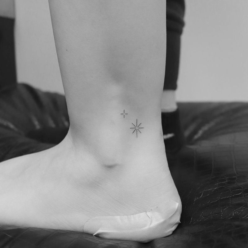 Black-and-white photo of ankle with two small star tattoos