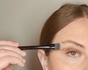 makeup artist applies concealer for brows