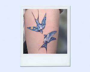 two blue birds tattooed on an arm