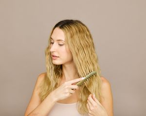 woman combing wavy blond hair