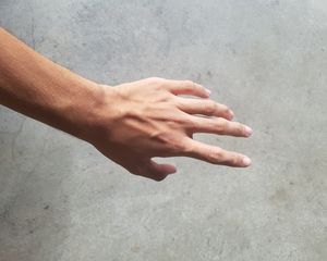 hand against grey cement wall