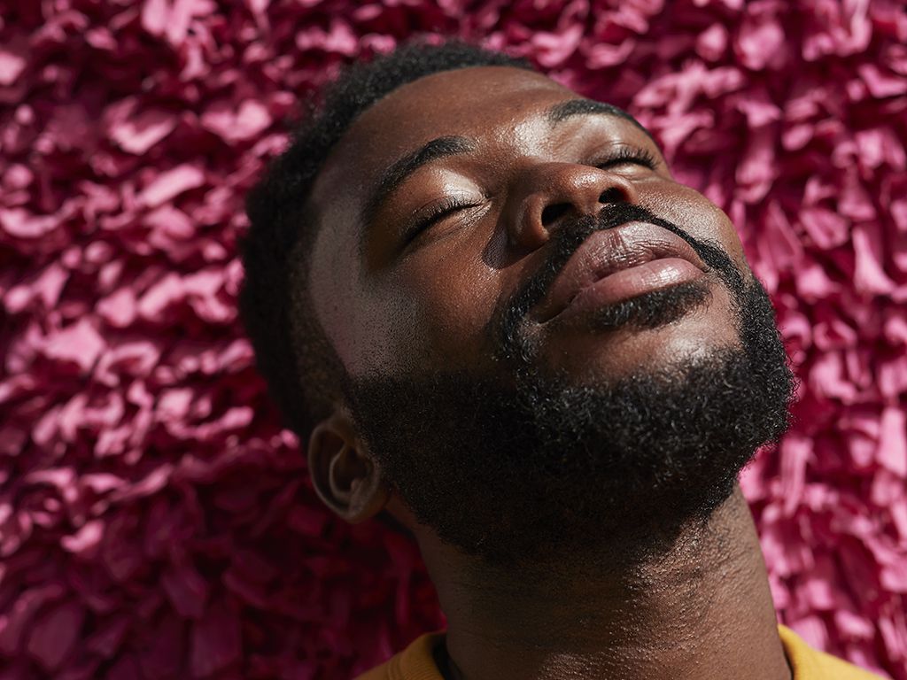 Man with a beard bathes his face in the sun