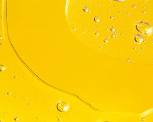 Oil texture with bubbles on yellow background