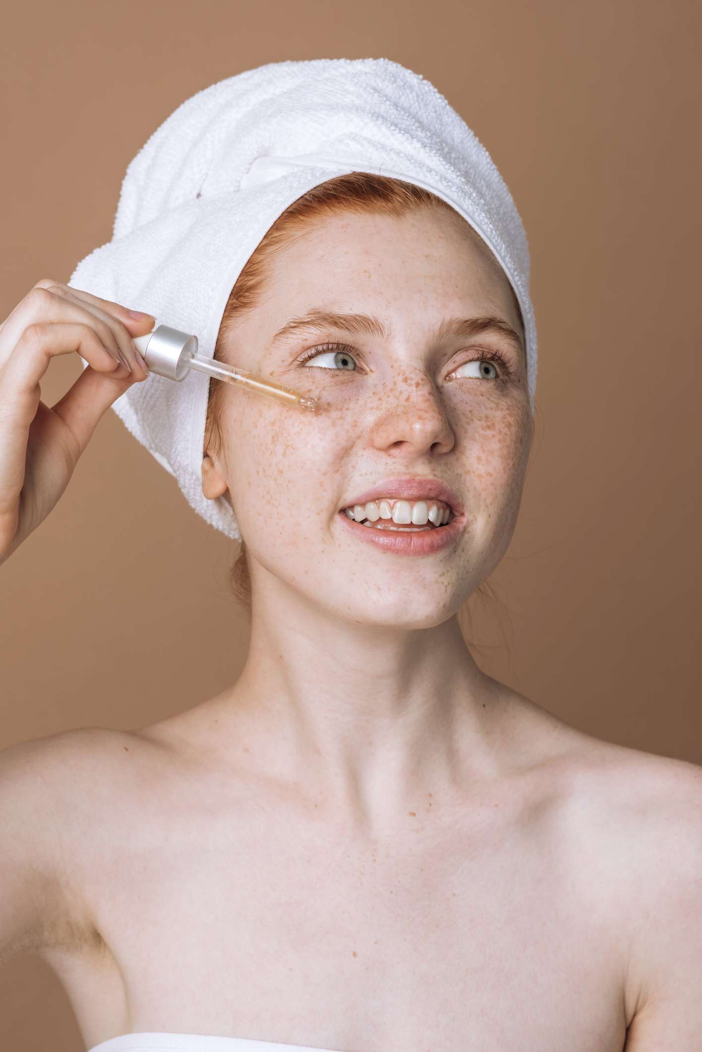 Woman applying a serum to her face