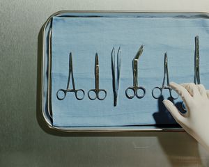 Surgeon's hand reaching for surgical tools