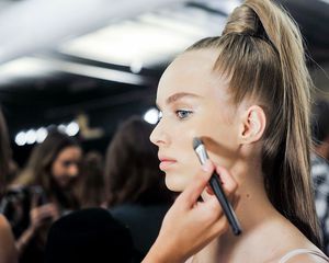 Model getting makeup done before a runway show