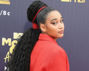 Amandla Stenberg wears a high ponytail with wavy braiding hair extensions and red string