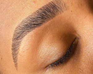 Close-up of woman's tinted eyebrow with eyes closed