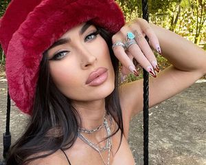 Megan Fox in a red hat with a bloody manicure 