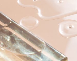 Close up of a skincare liquid on a pink background