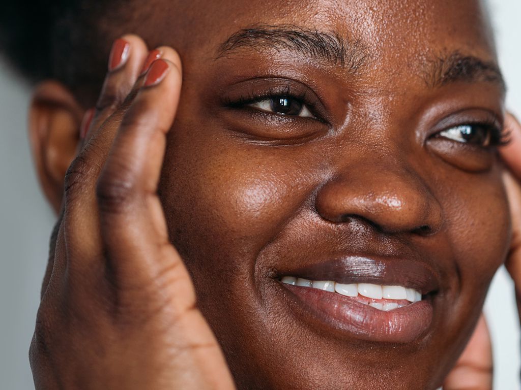 Smiling woman with her fingers at her temples