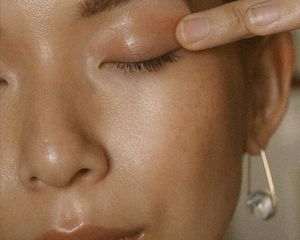 close-up of woman putting on eye cream