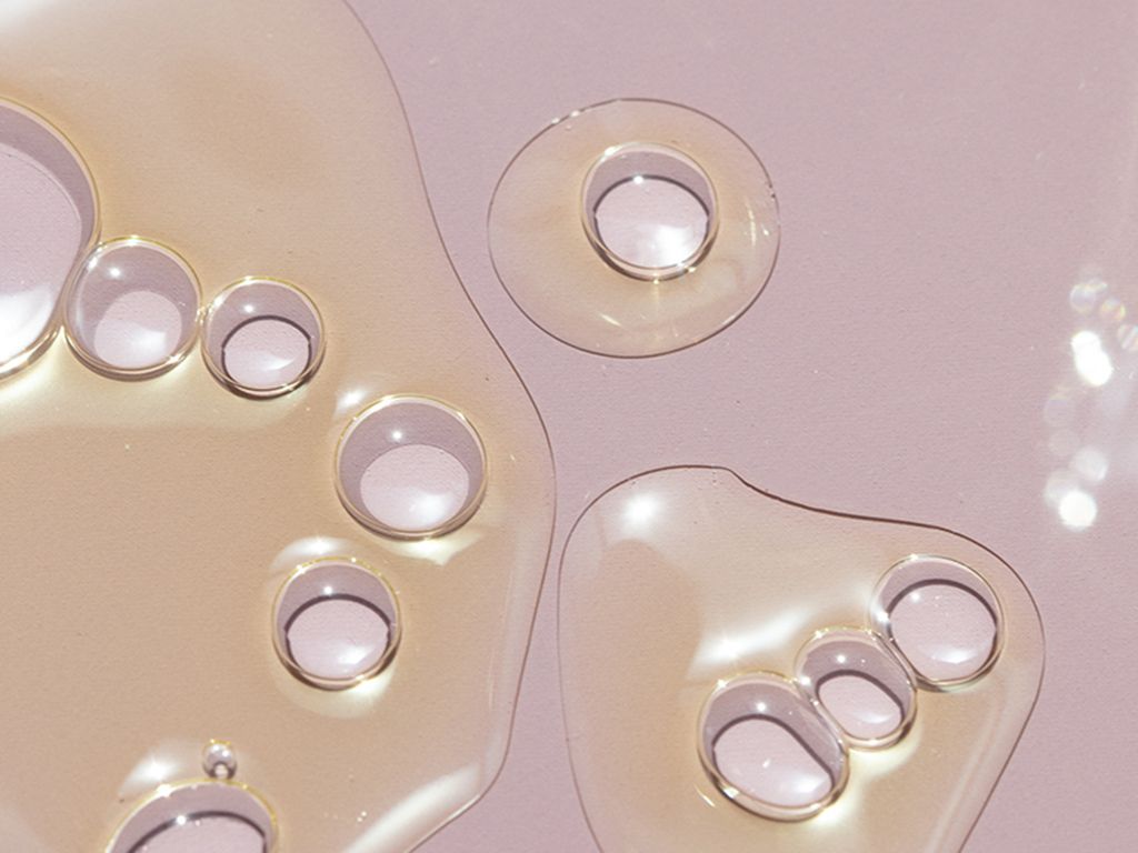 Drops of oil on a pink background