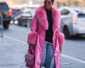 Woman wearing a fur-lined pink coat and pink sunglasses during NYFW in Feb. 2022.