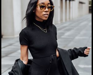 woman wearing an all-black outfit with silk hair and sunglasses