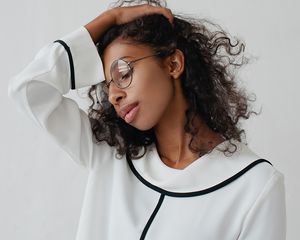 woman touching her hair and wearing a white blouse