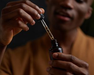 man holding vial of tea tree oil