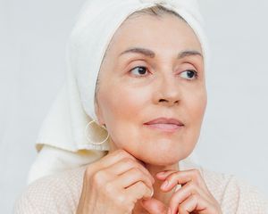 Up close of a woman in her 60s, with a towel on her head