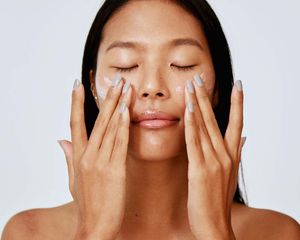 person applying face lotion retinol