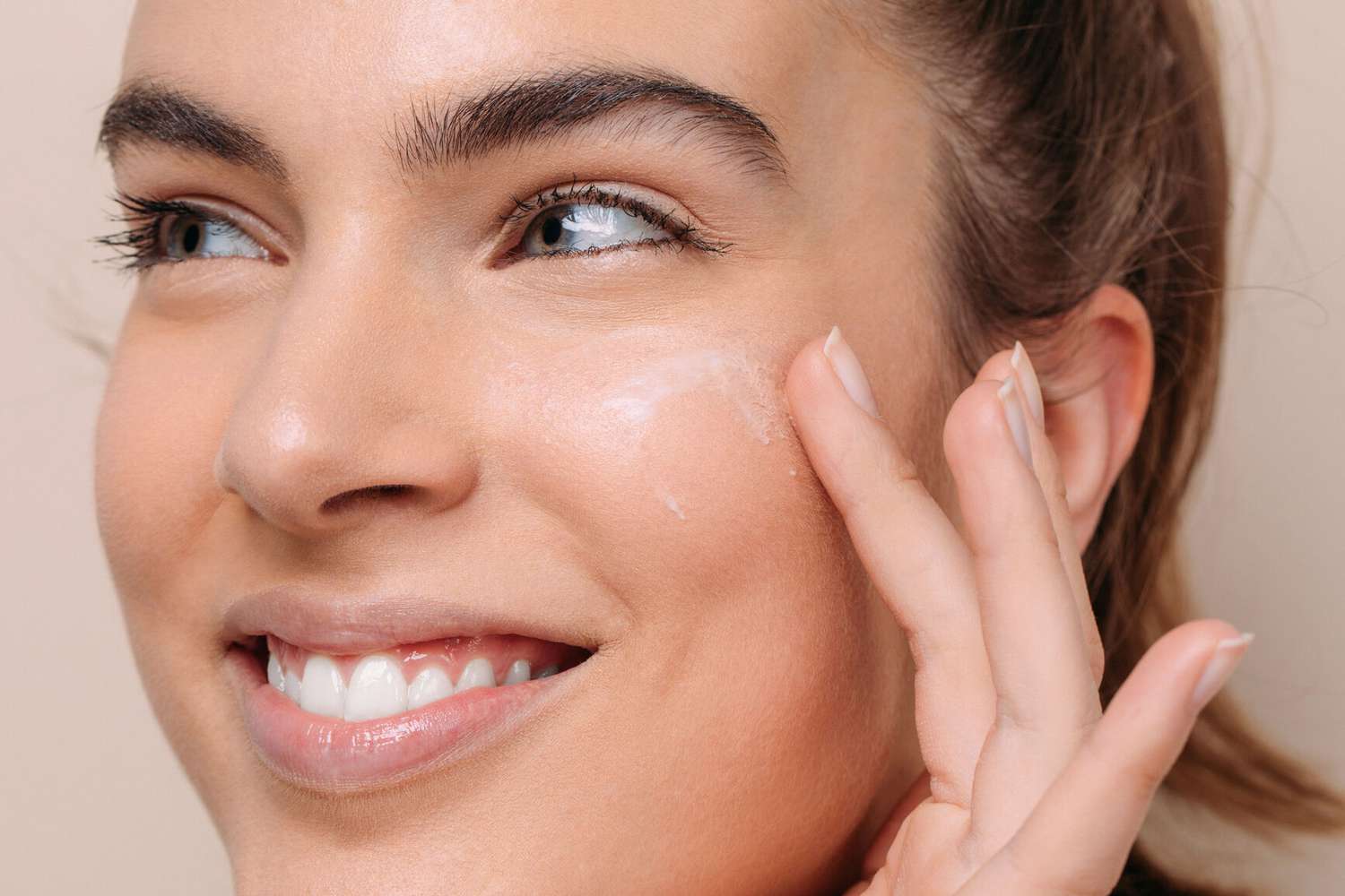 woman putting mask on her face