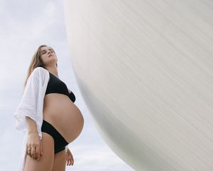 Pregnant woman looks up towards the sun