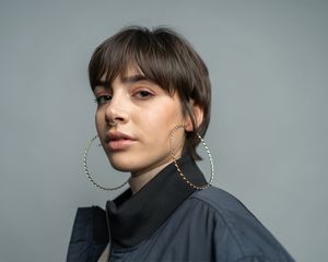 stylish young woman with hoop earrings and septum piercing