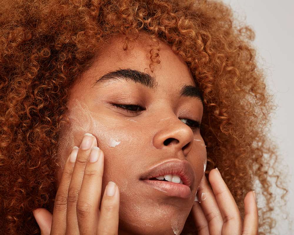 woman applying sunscreen to face