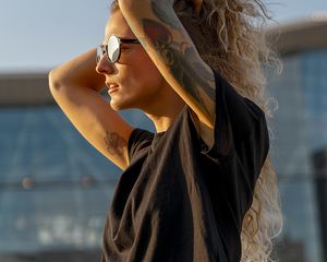 Woman with arm tattoos and sunglasses on