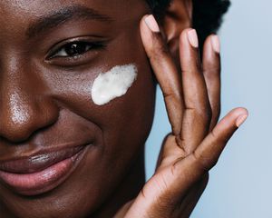 black femme applying face cream