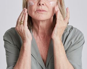 mature woman applying a cream to her face
