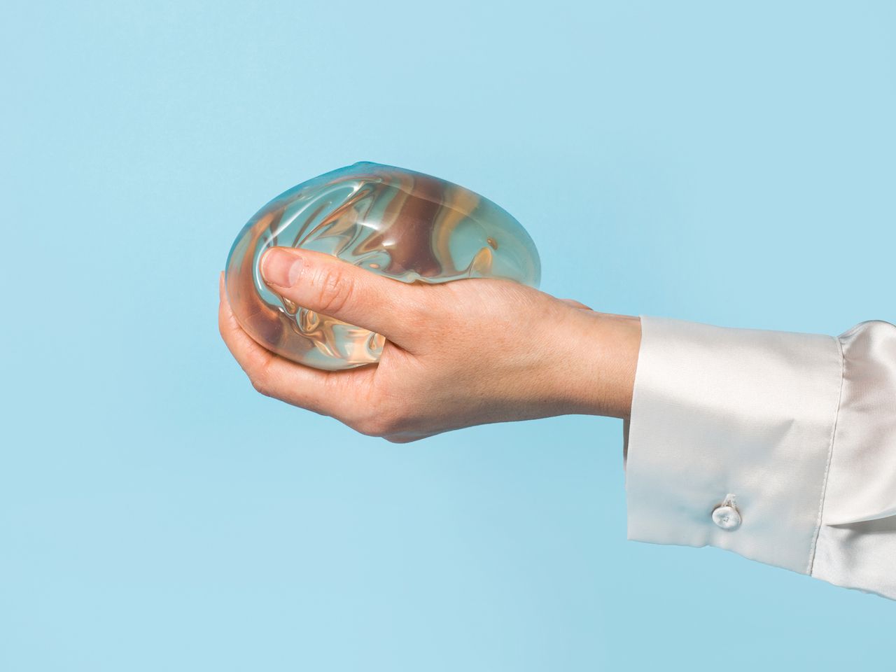 Woman's hand holding a breast implant