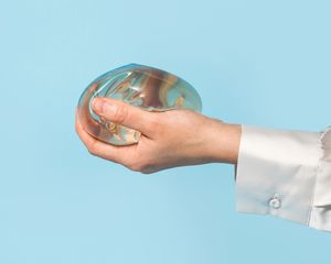 Woman's hand holding a breast implant