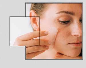 Woman performing gua sha on her jawline.