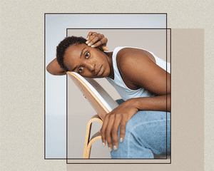 BIPOC Portrait Sitting Down Against a Chair with a Long Buzzcut Style Haircut Against Abstract Background